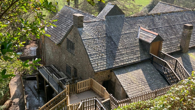 A view of Dunster Working Watermill and new bin floor dormer door from the Circular Path, Dunster Castle, Somerset